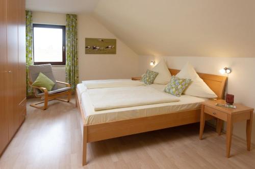 a bedroom with a bed and a chair and a window at Ferienhaus Meyer in Gunzenhausen