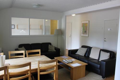 a living room with a black couch and a table at Leksands Folkhögskola in Leksand