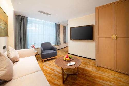 a living room with a couch and a tv at Guangzhou Wogo Yuanbao Hotel-Zhujiang New Town-Free Canton Fair Shuttle Bus & Overseas Buyer Registration Services in Guangzhou