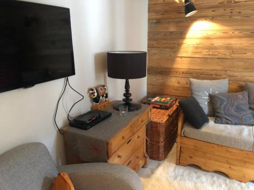 a living room with a tv and a couch and a lamp at Tignes : cocon luxueux au pied des pistes in Tignes