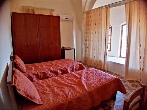 ein Schlafzimmer mit einem roten Bett und einem Fenster in der Unterkunft Lamar Guesthouse - Hebron in Hebron