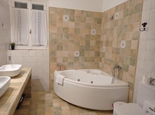 een badkamer met een wit bad, een wastafel en een toilet bij Marina Traditional Stonehouse in Afétai