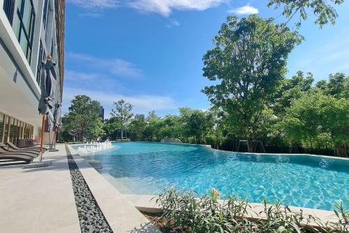 une grande piscine avec une fontaine en face d'un bâtiment dans l'établissement CARAMEL COZY @ ATMOZ BANGNA (Si Iam MRT.), à Ban Khlong Samrong