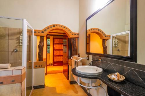 La salle de bains est pourvue d'un lavabo et d'un miroir. dans l'établissement Leopard Walk Lodge, à Hluhluwe