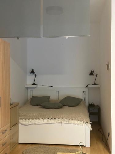 een wit bed met twee lampen erop bij S3 Residences Ilka Studio Serviced Cozy Appartment in Boedapest