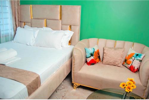 a bedroom with a bed and a couch and a table at Emap Homes- Golf studio in Kilifi