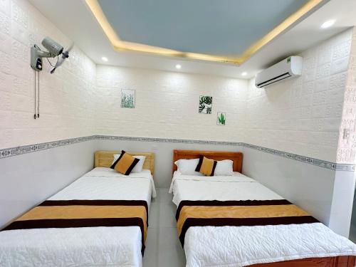 2 Betten in einem Zimmer mit weißen Wänden in der Unterkunft Hotel Thuý Nguyễn 