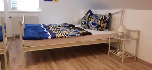 a bedroom with a bed with blue and white blankets and pillows at Am Bahnhof in Hochkirch