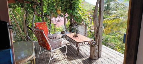 une terrasse couverte avec une table et une chaise sur une terrasse dans l'établissement Tite caz' écolo gîtes des Koalas, à Terre-de-Bas
