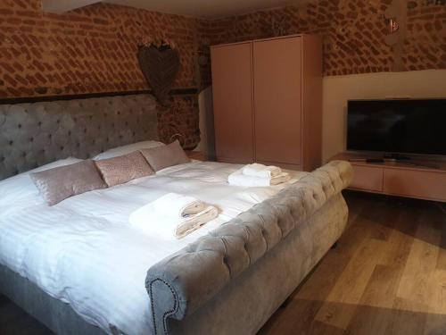 a bedroom with a large white bed with towels on it at Luxury barn with hot tub (Dogs Welcome) in Roughton
