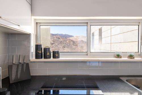 a kitchen with a window with a view of the mountains at Desert and Sea-penthouse Full Sea view in Eilat