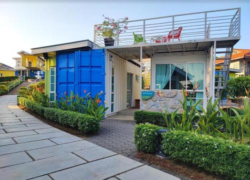 uma casa azul com uma varanda em cima em Solesor Kampong Beach Resort em Port Dickson