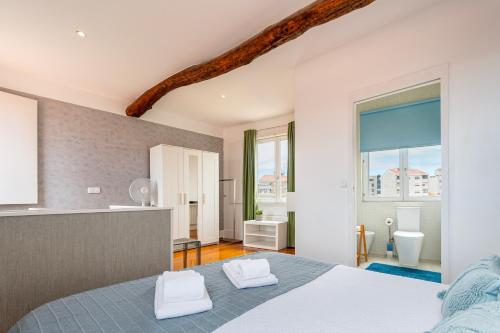 um quarto com uma cama e uma casa de banho com um lavatório em Your OWM Porto no Porto