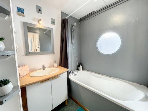 ein Badezimmer mit einer Badewanne, einem Waschbecken und einer Badewanne in der Unterkunft Appartement Granville, 2 pièces, 2 personnes - FR-1-361-428 in Granville