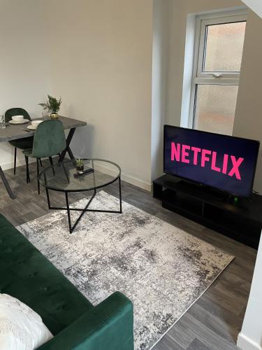 a living room with a tv with the netflix sign at Apartment with Balcony Sea Views with parking - Sleeps 4 in Westcliff-On-Sea