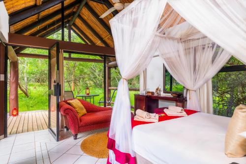 a bedroom in a villa with a view of the garden at Leopard Walk Lodge in Hluhluwe