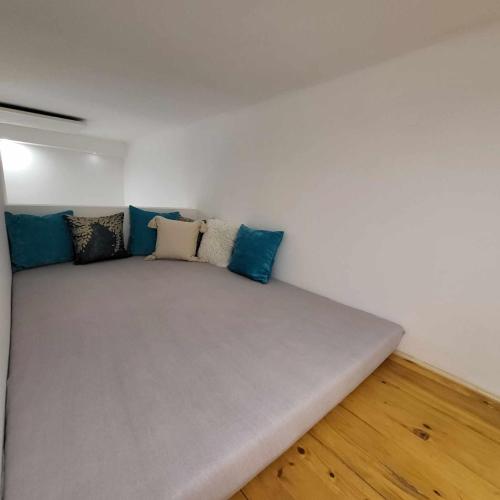 a couch in a room with blue pillows on it at City Bell in Székesfehérvár