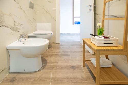 y baño con aseo, lavabo y mesa. en My Home Catania Rooms, en Catania