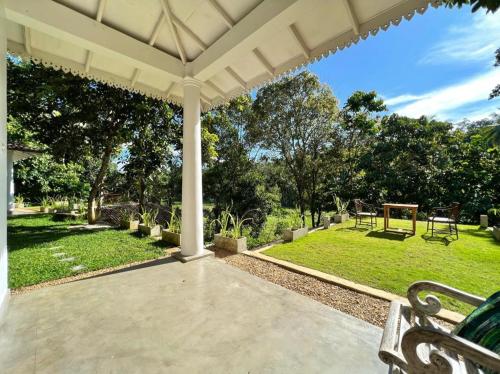 a porch with a bench and a park at The Jungle Loft Galle in Galle