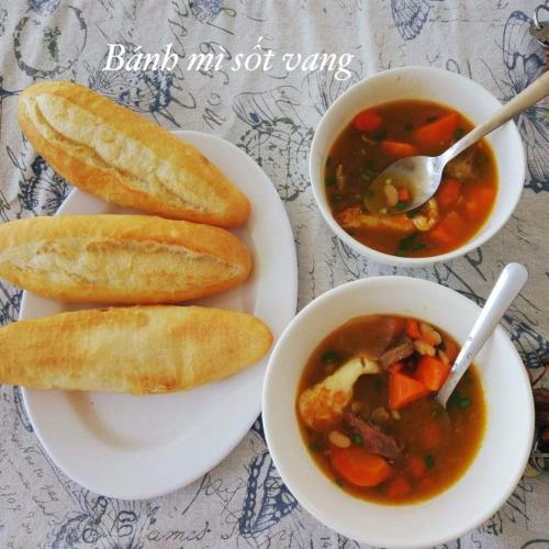 drei Teller Essen mit Suppe und einer Schüssel Brot in der Unterkunft Mộc House in Mộc Châu