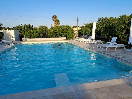 a swimming pool with two people in the water at L'Antico Trappeto in Noto