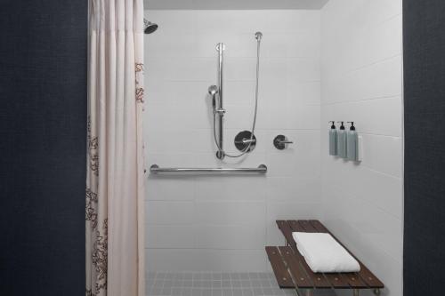 a bathroom with a shower with a towel on a bench at Residence Inn Holland in Holland
