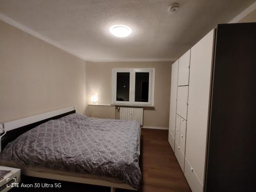 a small bedroom with a bed and a window at Apartment am Schillerteich in Wolfsburg