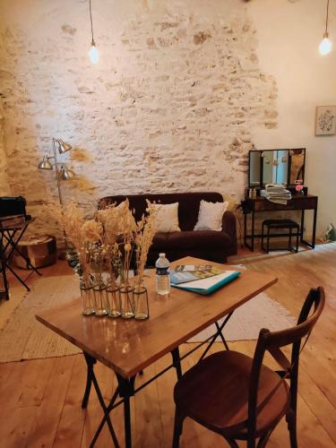 sala de estar con mesa y sofá en Chamade en Beaujolais, en Anse