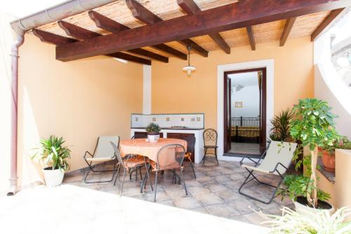 un patio con mesa, sillas y chimenea en Residence Marina Corta, en Lipari