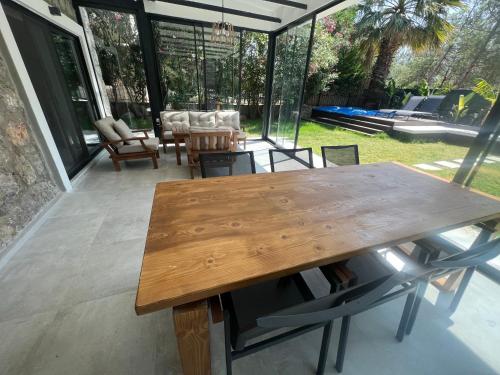 ein Holztisch und Stühle auf einer Terrasse in der Unterkunft Oludeniz Luxury Villa with Jacuzzi, Common Pool in Fethiye