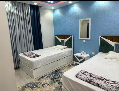 a hotel room with two beds and a mirror at شقة مفروشة بالقاهرة مدينة المستقبل in Madīnat ash Shurūq