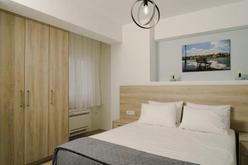 a bedroom with a bed with a wooden headboard at EDEL Luxury Apartments in Chania