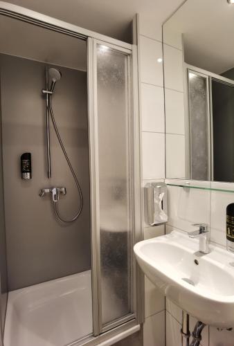 a bathroom with a shower and a sink at Hotel Italia in Munich