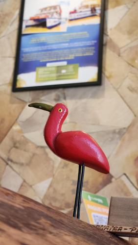 a red bird statue sitting on top of a table at Pousada Vila Cajuína - Parnaíba in Parnaíba