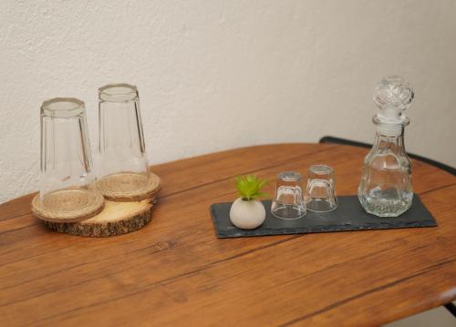 uma mesa de madeira com três garrafas de vidro e um vaso em Το Μπαλκόνι Του Όρλιακα 