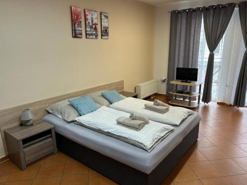 1 dormitorio con 1 cama grande y toallas. en Kondé Apartments C, en Dunajská Streda