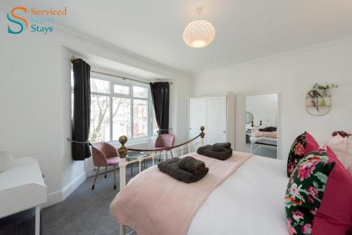 a bedroom with a large bed with a table and chairs at Light and spacious three bedroom house in Margate close to beach and amenities in Margate