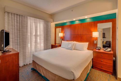 a hotel room with a large bed and a television at Residence Inn Ocala in Ocala