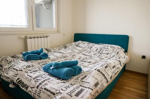 a bed with two blue towels on top of it at Apartman “Ada” in Sarajevo