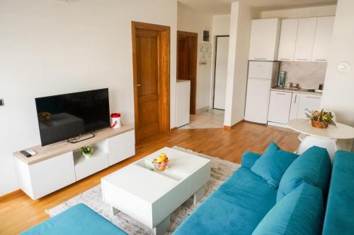 a living room with a blue couch and a tv at Apartman “Ada” in Sarajevo