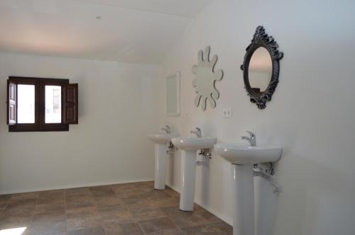 ein Badezimmer mit 2 Waschbecken und einem Spiegel an der Wand in der Unterkunft Albergue Gares in Puente la Reina