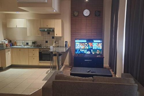 een woonkamer met een tv in een keuken bij 409 Mapungubwe Hotel in Johannesburg