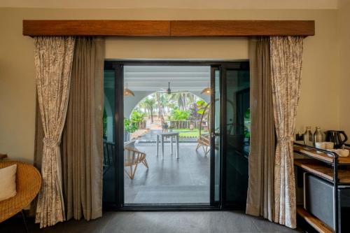 sala de estar con puerta que da a un patio en C Roque Beach Resort, en Colva