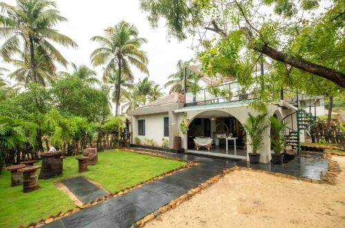 an exterior view of a house with a yard at C Roque Beach Resort in Colva