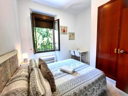a bedroom with a bed and a window at Budget & Lovely Rooms Las Setas in Seville