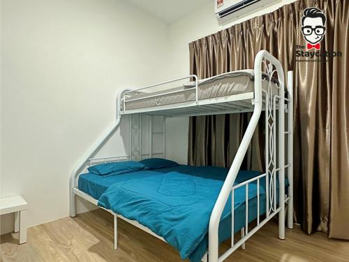 Staycation Homestay 14 P Residence kuching condo في كوتشينغ: غرفة نوم مع سرير بطابقين مع ملاءات زرقاء