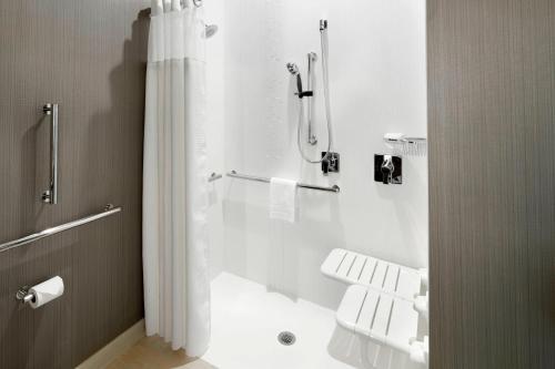 a white bathroom with a shower and a toilet at Courtyard by Marriott Houston Intercontinental Airport in Houston