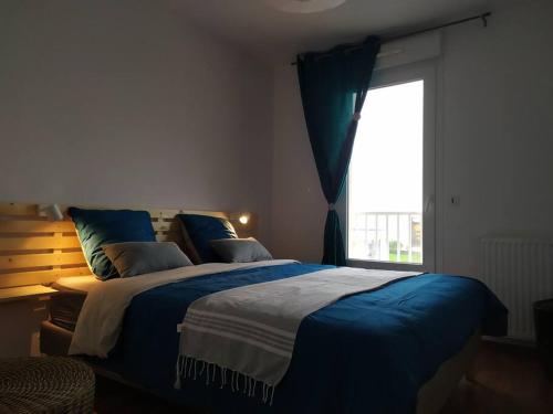 een slaapkamer met een groot bed en een raam bij Très bel F2 avec pleine vue mer. in Langrune-sur-Mer