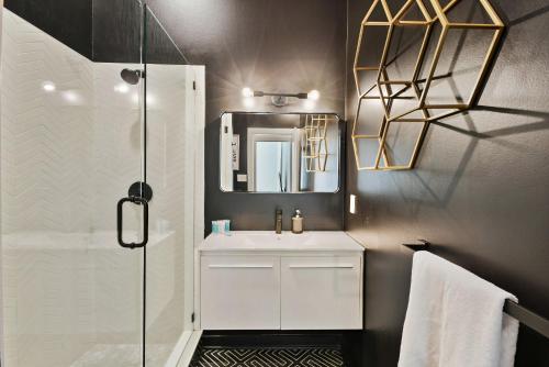 a bathroom with a white sink and a mirror at Iridescence Center Midtown Piedmont Park King Bed Loft in Atlanta