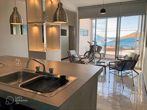 a kitchen with a sink with a view of the ocean at Increíble departamento en malecón frente al mar in Mazatlán